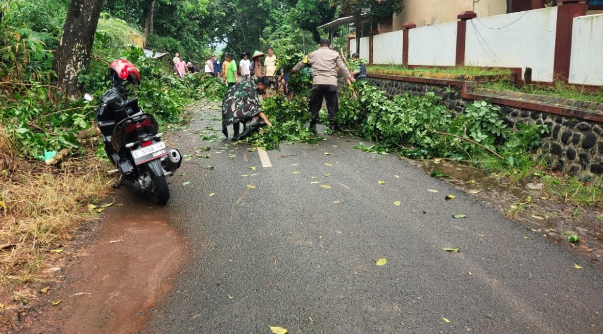 Sinergitas Bhabinkamtibmas dan Babinsa Bersama Warga Buka Akses Jalan yang Tertutup Akibat Pohon Tumbang